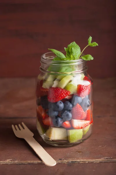 Ensalada de frutas en tarro de albañil fresa kiwi kiwi manzana menta — Foto de Stock