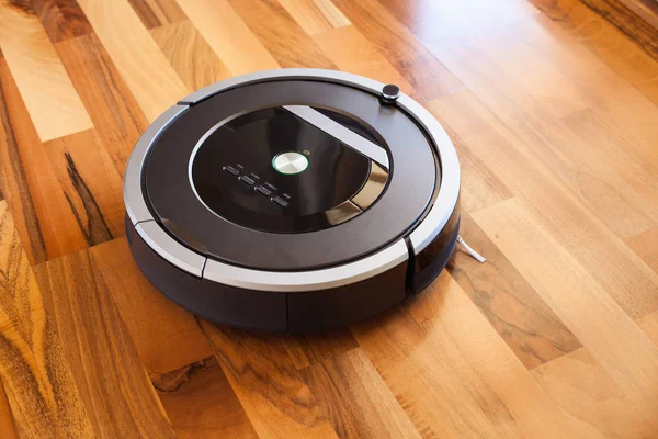 Robotic vacuum cleaner on laminate wood floor smart cleaning tec — Stock Photo, Image