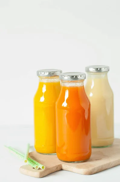 Batidos de frutas y verduras en frascos de vidrio, plátano de mango naranja —  Fotos de Stock