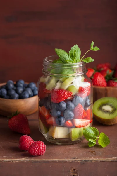 Ensalada de frutas en tarro de albañil fresa kiwi kiwi manzana menta — Foto de Stock