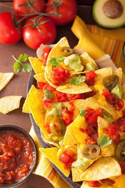 Nachos loaded with salsa, guacamole, cheese and jalapeno — Stock Photo, Image