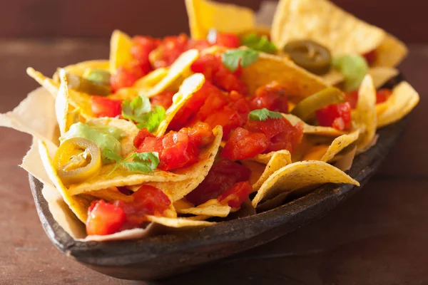 Nachos loaded with salsa, guacamole, cheese and jalapeno — Stock Photo, Image