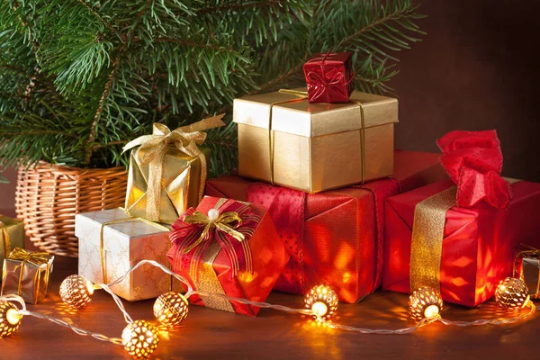 Červená a zlatá vánoční dárková krabice a dekorace světlo — Stock fotografie