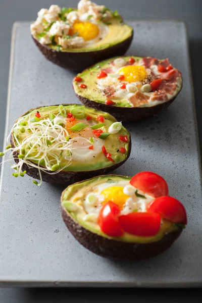 Eier in Avocado gebacken mit Speck, Käse, Tomaten und Luzerne — Stockfoto