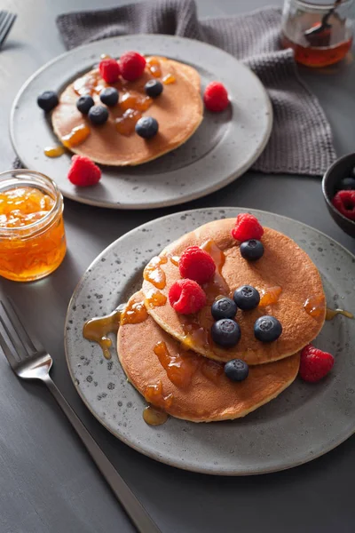 Pannkakor med blåbär hallon honung och sylt till frukost — Stockfoto