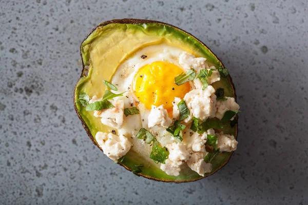 Яйцо, приготовленное в авокадо с сыром и травами — стоковое фото