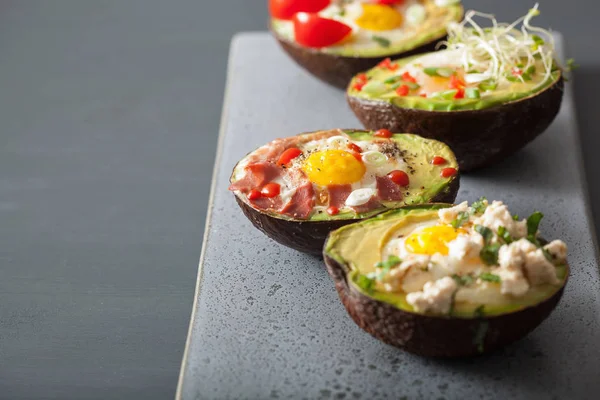 Eier in Avocado gebacken mit Speck, Käse, Tomaten und Luzerne — Stockfoto