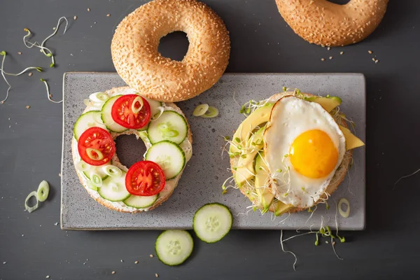 Broodjes op bagels met ei, avocado, zachte kaas, tomaat, cuc — Stockfoto