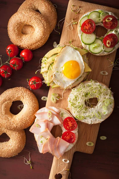Különféle szendvicsekkel a bagel: tojás, avokádó, sonka, paradicsom, puha — Stock Fotó