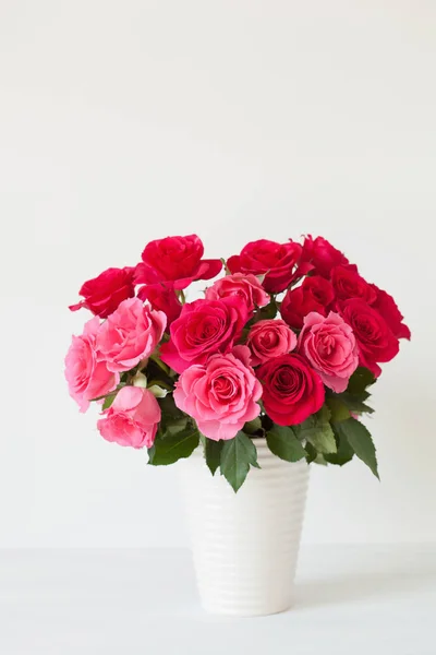 Hermoso ramo de flores de rosa roja en jarrón sobre blanco — Foto de Stock