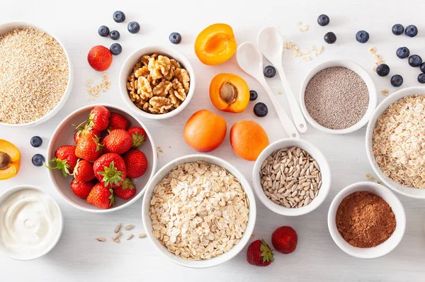 Verschiedene rohe Getreidesorten, Früchte und Nüsse zum Frühstück. Haferflocken — Stockfoto