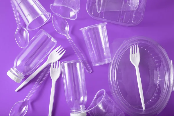 single use plastic bottles, cups, forks, spoons. concept of recy