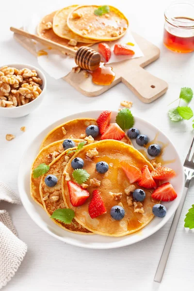 Pancake dengan madu blueberry strawberry dan kacang untuk sarapan — Stok Foto