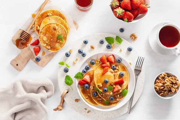 Pancake dengan madu blueberry strawberry dan kacang untuk sarapan — Stok Foto