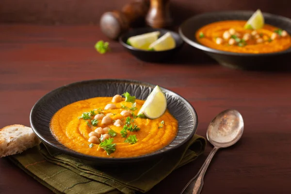 Sopa de grão de bico de cenoura cremosa no fundo rústico escuro — Fotografia de Stock