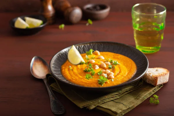 Sopa de grão de bico de cenoura cremosa no fundo rústico escuro — Fotografia de Stock