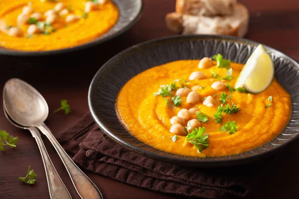 Creamy carrot chickpea soup on dark rustic background — Stock Photo, Image