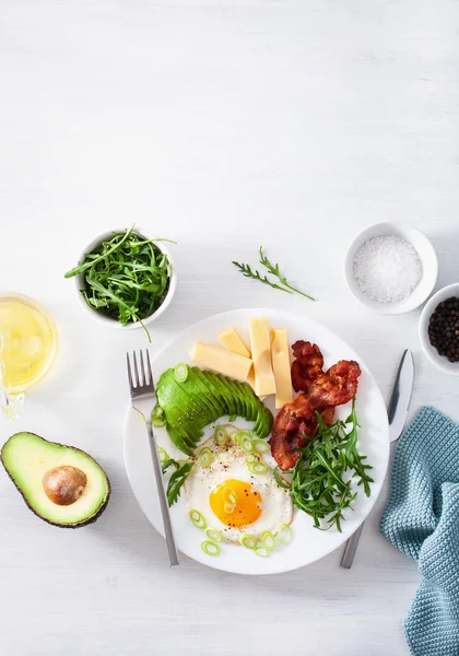 Healthy keto breakfast: egg, avocado, cheese, bacon — Stock Photo, Image