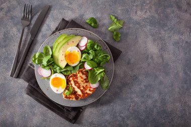 Sağlıklı keto paleo diyet kahvaltı: haşlanmış yumurta, avokado, halloumi