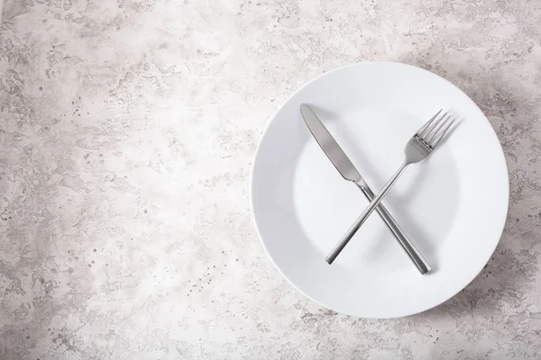 间歇性禁食和产茶饮食的概念 体重减轻 叉子和刀叉叉在盘子上 — 图库照片