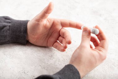 Erkek elleri kan şekeri ve keton seviyelerini glikoz ölçmek için parmak üstüne mızrak kullanır. İlaç diyabeti keto diyet sağlık hizmetleri evde