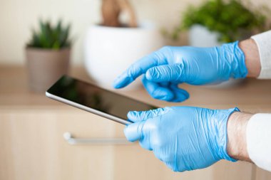 Adam eldivenlerini tablet bilgisayar kullanarak veriyor, koronavirüs bakterilerini engelliyor.