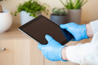 Adam eldivenlerini tablet bilgisayar kullanarak veriyor, koronavirüs bakterilerini engelliyor.