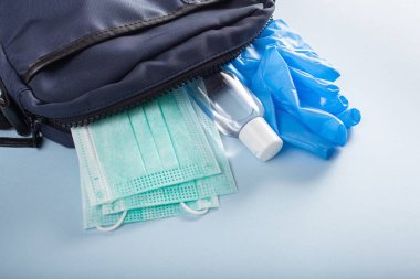 Koruyucu tıbbi maske, dezenfektan jeli ve pembe çantada eldivenler. Virüs ve bakterilere karşı koruyucu önlemler