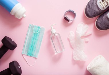 Koruyucu tıbbi maske dezenfekte jeli eldivenleri. Evde spor ayakkabı eğitimi, dambıl ve virüs ve bakterilere karşı koruyucu önlemler.