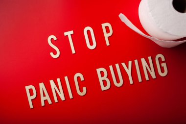 Paniğe kapılıp tuvalet kağıdı almayı kes. Kırmızı arkaplan koronavirüs covid-19 'un tahta harfini yaz.