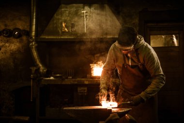 Blacksmith with brush handles the molten metal  clipart