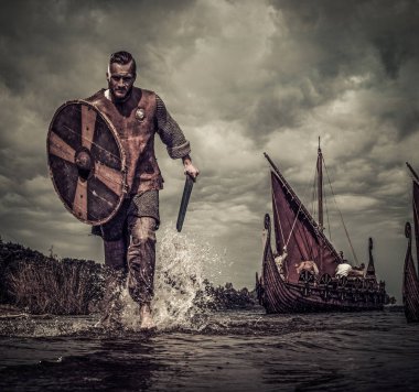 Viking warrior in attack, running along the shore clipart
