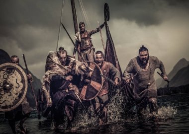 Mad vikings warriors in attack, running along shore with Drakkar  clipart