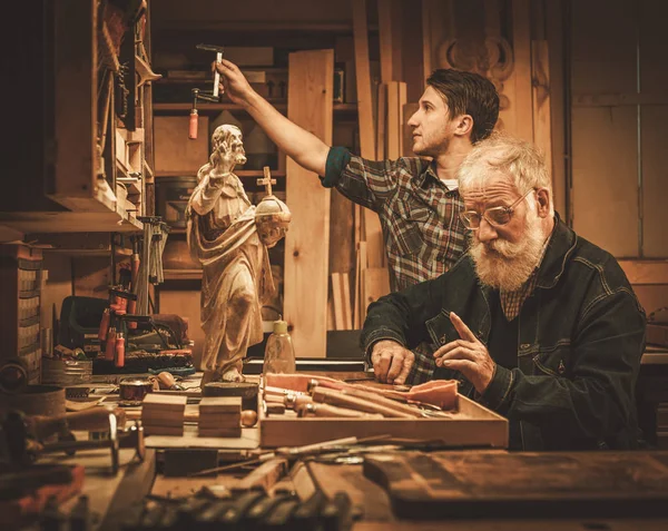 Restaurateur en zijn leerling werkt met antieke decor element — Stockfoto