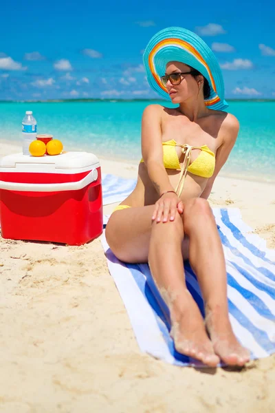 Vrouw in bikini zonnebaden op het strand — Stockfoto