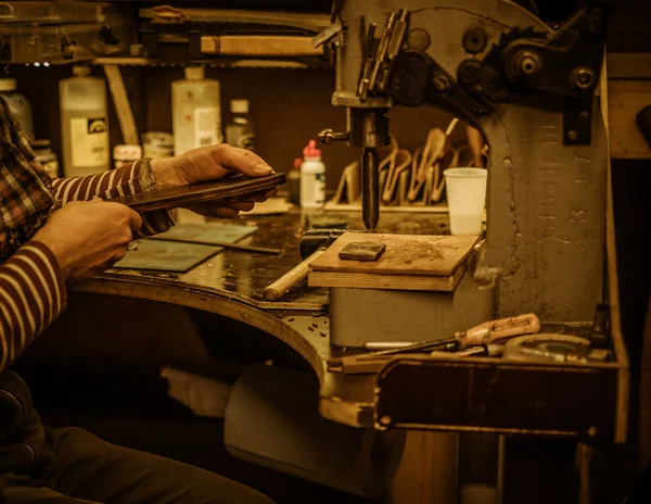 Blacksmith makes leather cover for axe — Stock Photo, Image