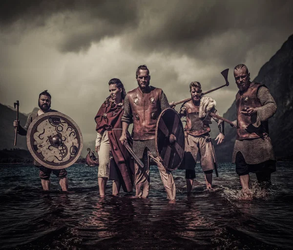 Un grupo de vikingos armados de pie en la orilla del río — Foto de Stock