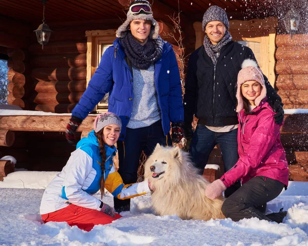 Wesoły znajomi z psem wspólnie spędzają ferie zimowe — Zdjęcie stockowe