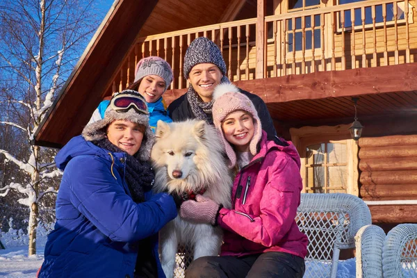 Fröhliche Freunde mit Hund verbringen Winterurlaub zusammen — Stockfoto