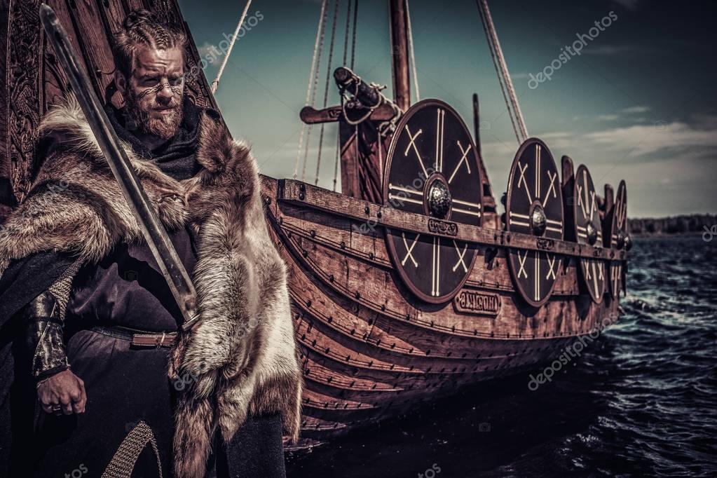 Viking warrior with sword standing near Drakkar — Stock 