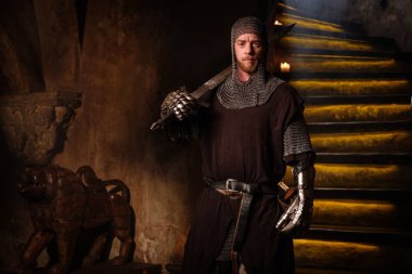 Medieval knight in ancient castle interior. clipart