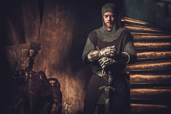 Medieval knight in ancient castle interior. — Stock Photo, Image