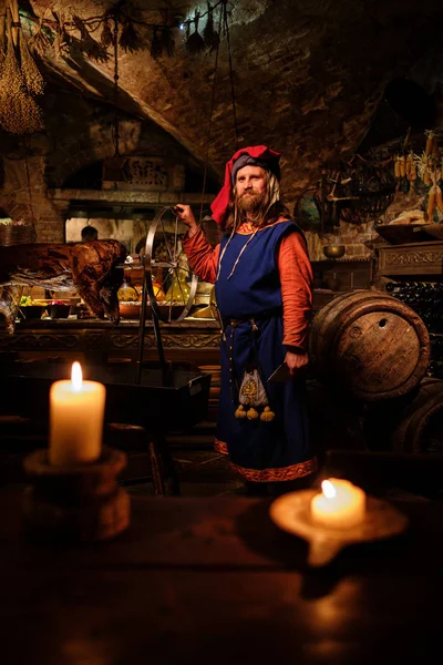 Hombre medieval haciendo cerdo asado en el estante —  Fotos de Stock
