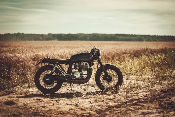 The vintage custom cafe racer in a field — Stock Photo, Image