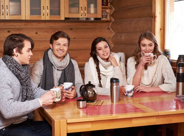 Mejores amigos beber té caliente en la acogedora cocina en la casa de campo de invierno —  Fotos de Stock