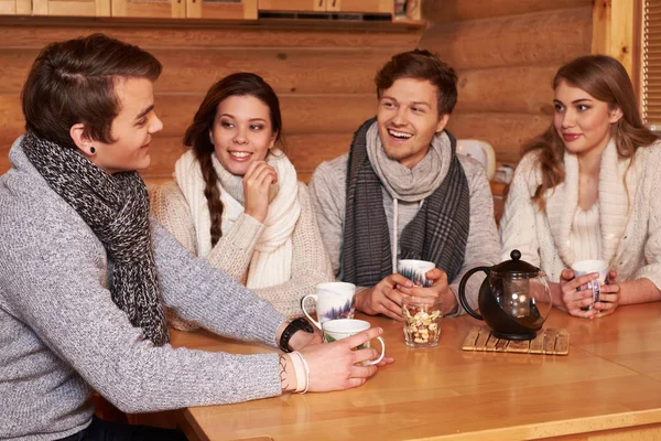 Migliori amici che bevono tè caldo in cucina accogliente al cottage invernale — Foto Stock