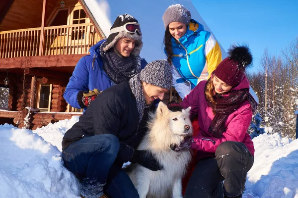 Los amigos alegres con el perro pasan las vacaciones invernales juntos —  Fotos de Stock