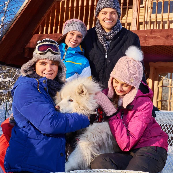 Vrolijke vrienden met hond vakantie winter samen in berg cottage — Stockfoto