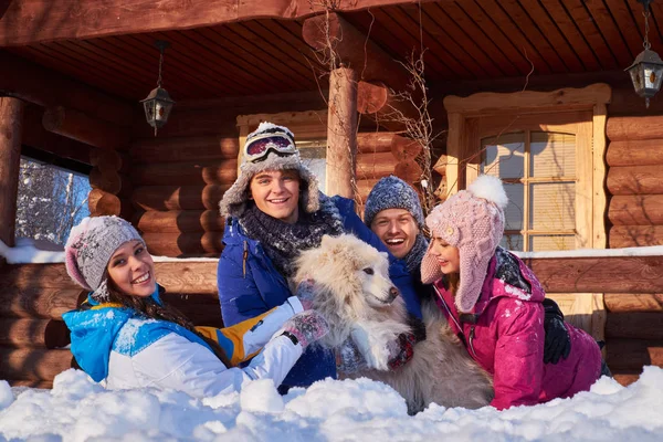 Веселые друзья с собакой проводят зимние каникулы вместе — стоковое фото