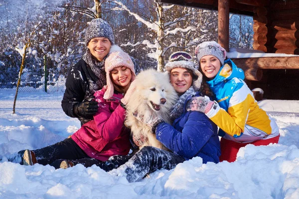Fröhliche Freunde mit Hund verbringen Winterurlaub zusammen — Stockfoto